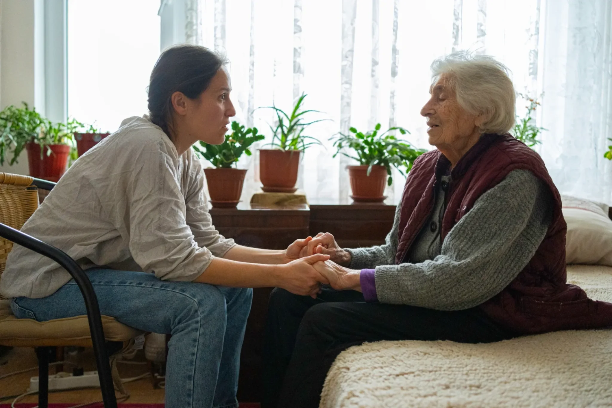 A caregiver holding the hands of an elderly person, representing trust and compassion